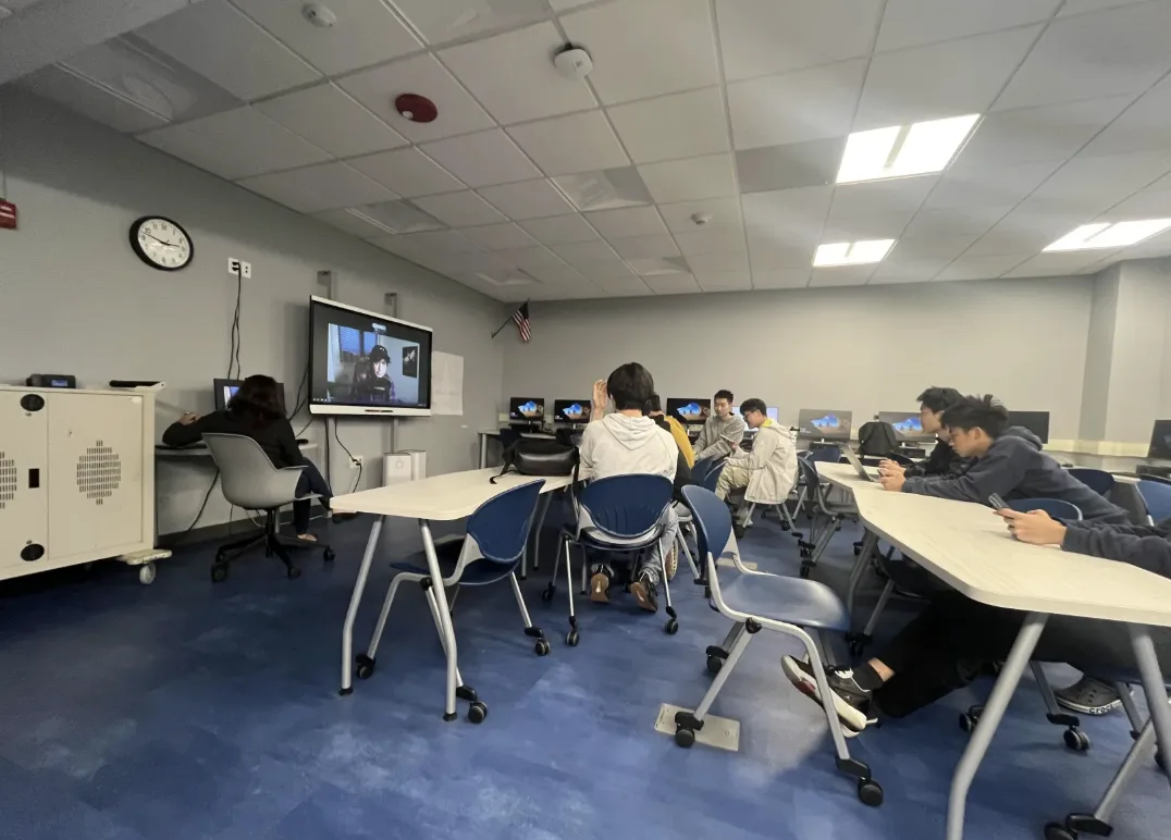 The whole lab during a meeting, members at every row of desktops