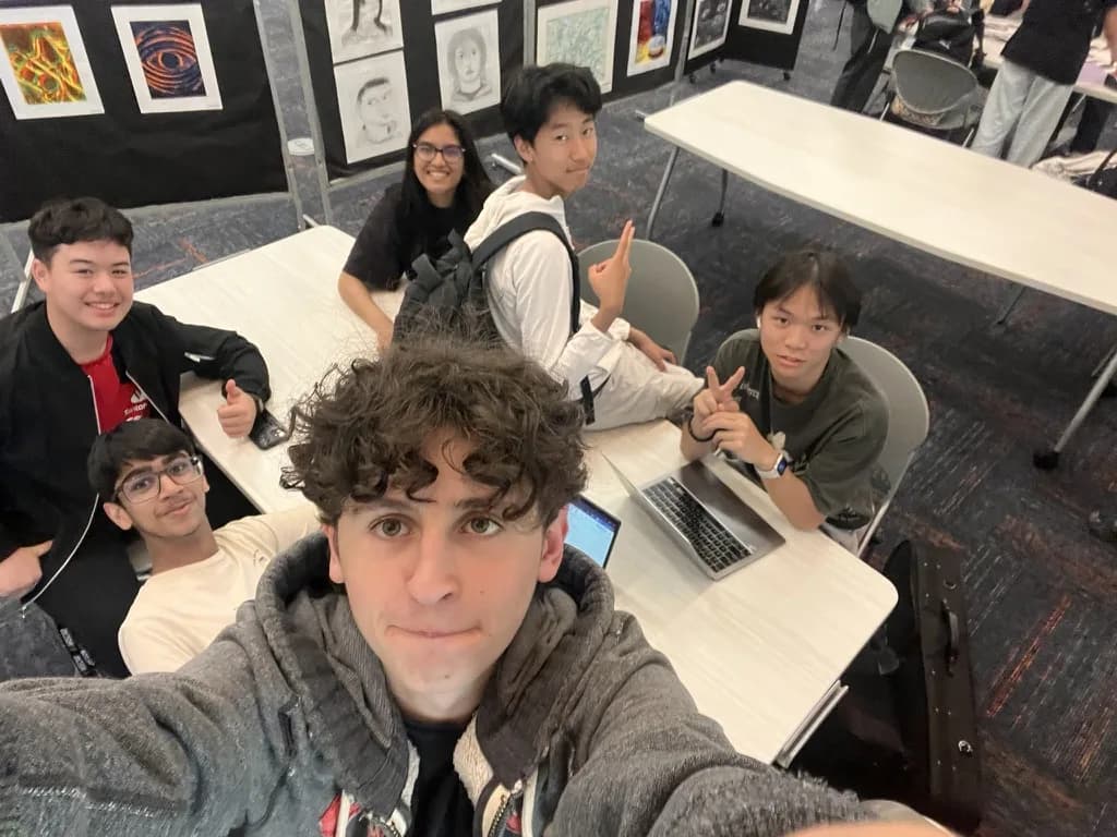 Members gathered around a laptop at a table in the lab