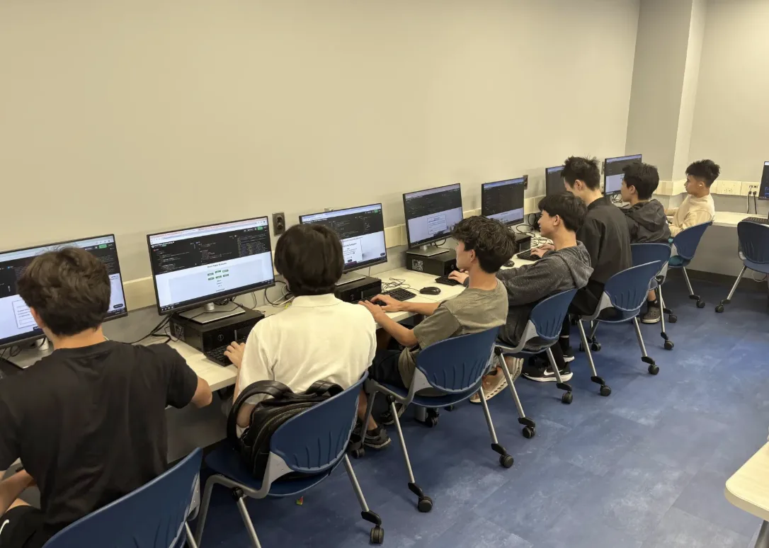 Rows of members working at the lab desktops with the same site open on every screen